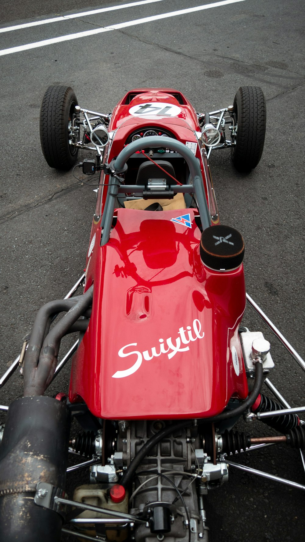 red and black go kart on gray asphalt road during daytime