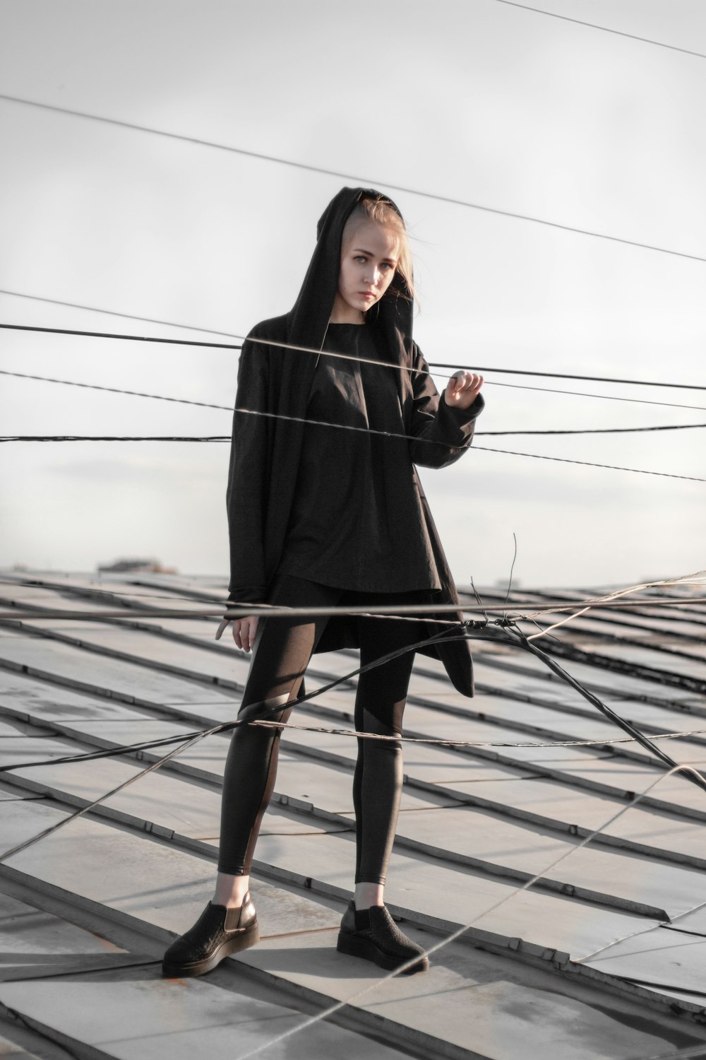 woman in black long sleeve dress standing on white metal fence during daytime