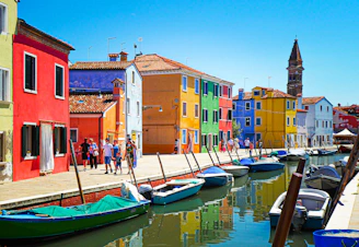 blue and white boat on water near brown concrete building during daytime