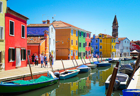 blue and white boat on water near brown concrete building during daytime