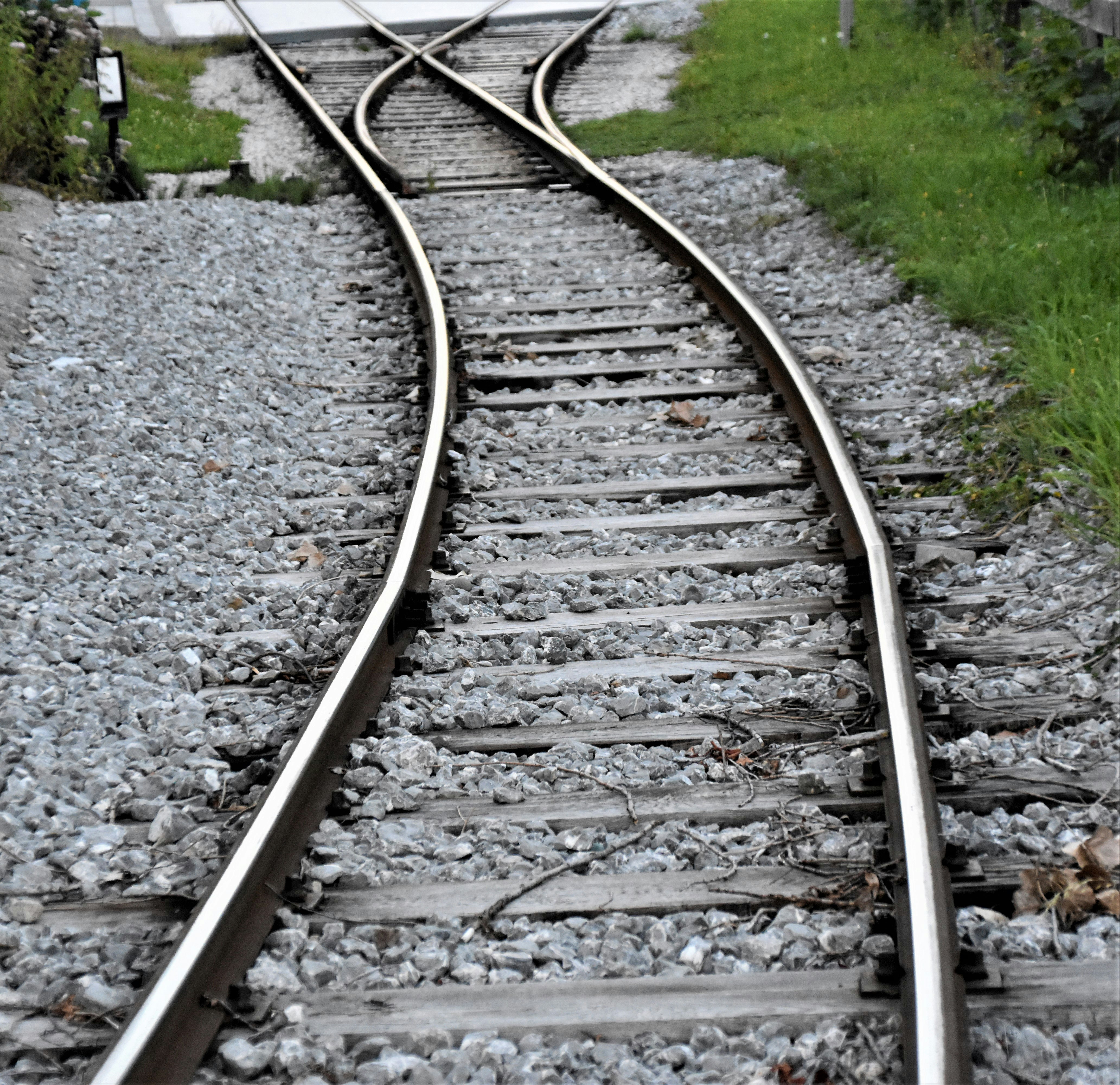 train rail tracks on green grass field during daytime