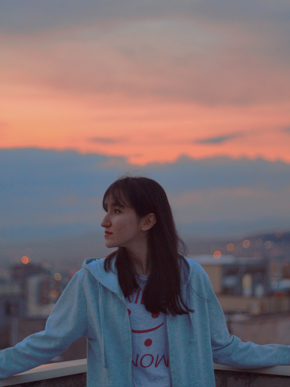 woman in blue hoodie standing during sunset