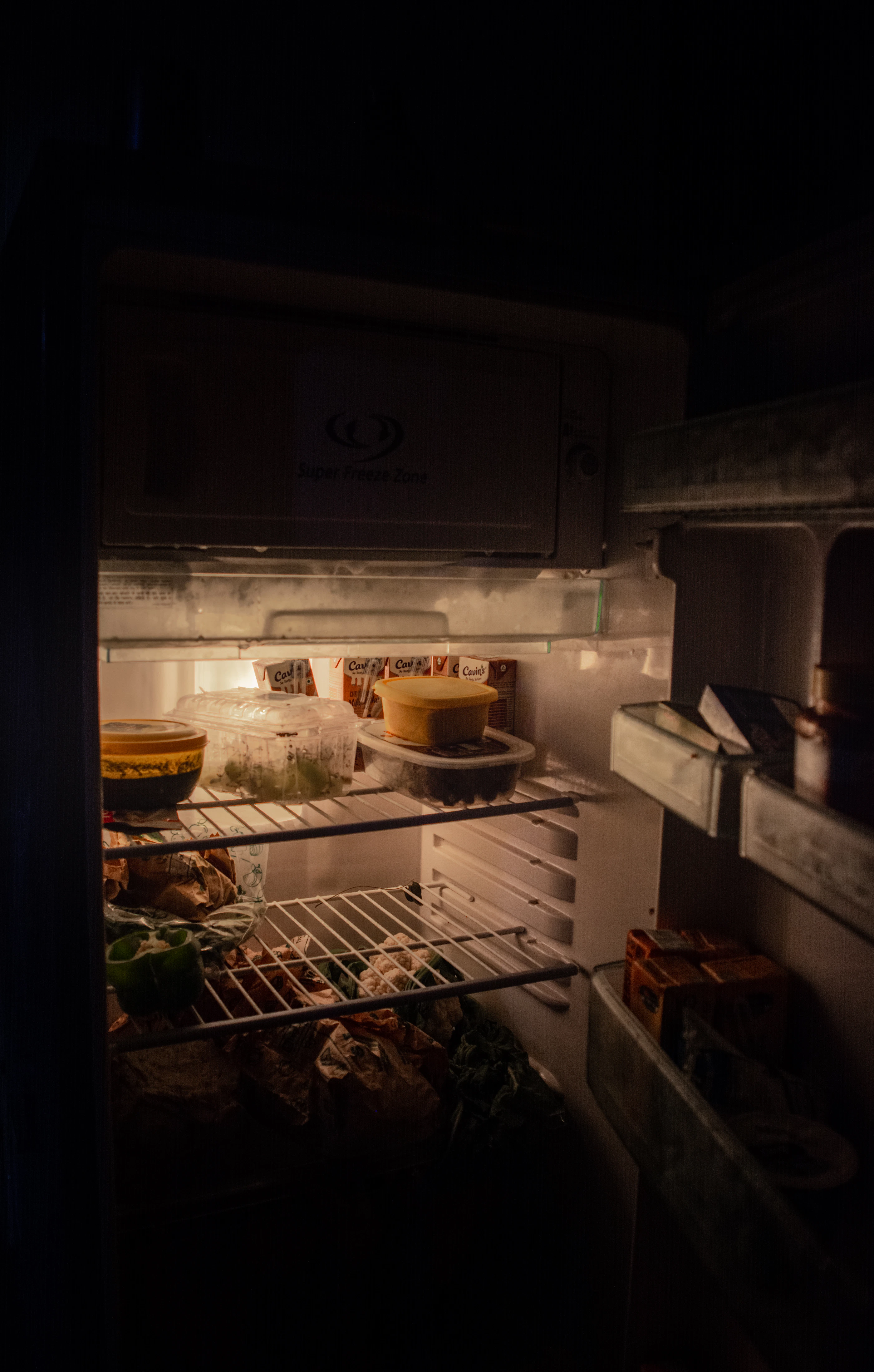 An open household refrigerator containing food