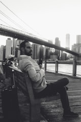 A traveler admiring a famous city landmark with a suitcase nearby.