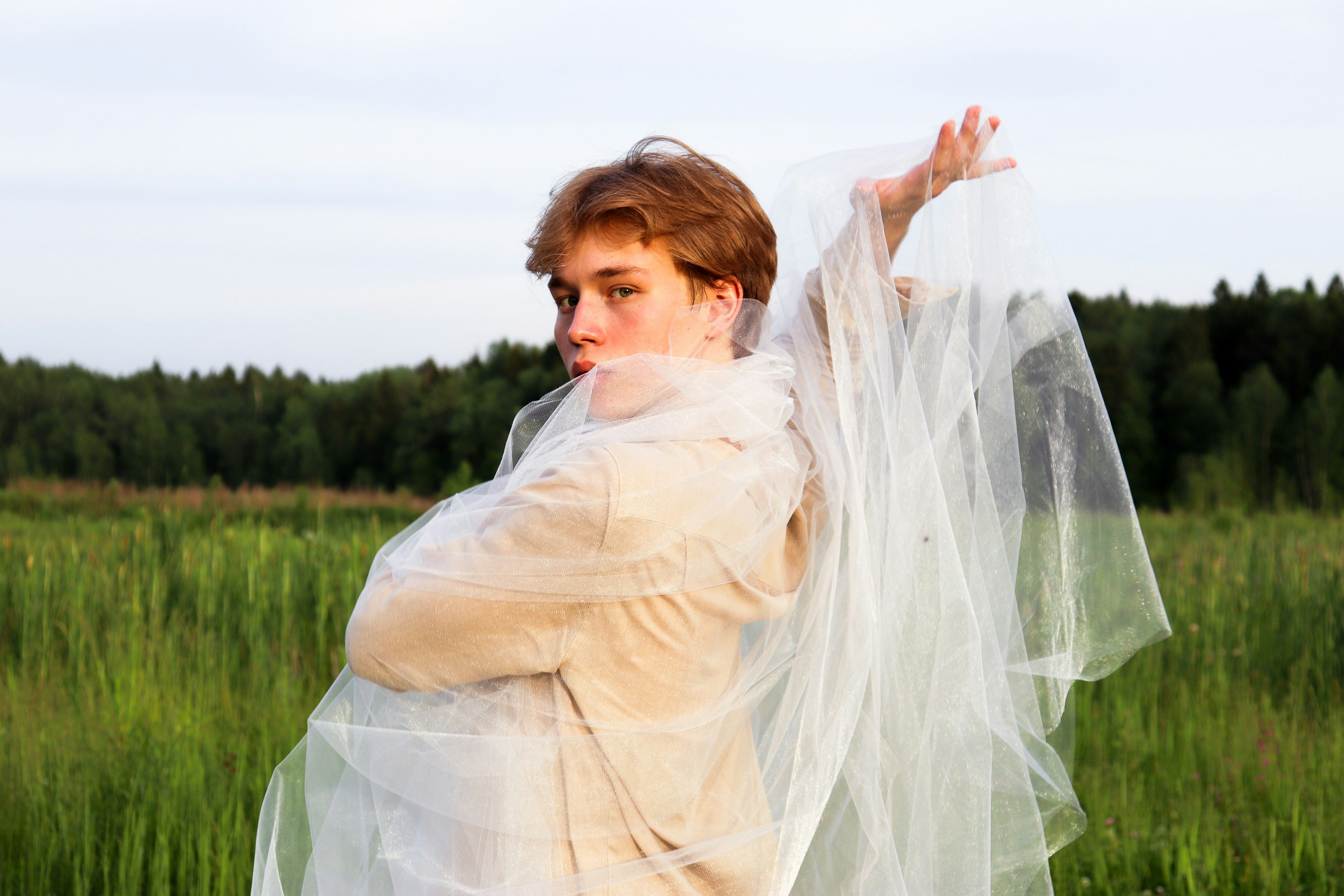 woman in white dress standing on green grass field during daytime