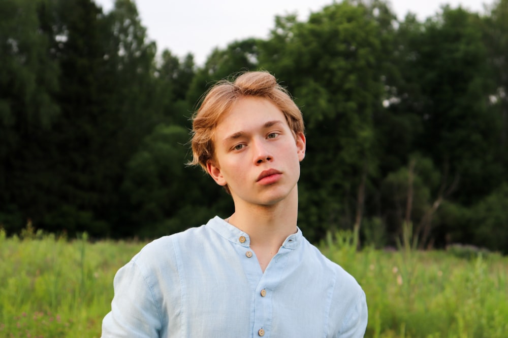 girl in white button up shirt standing on green grass field during daytime