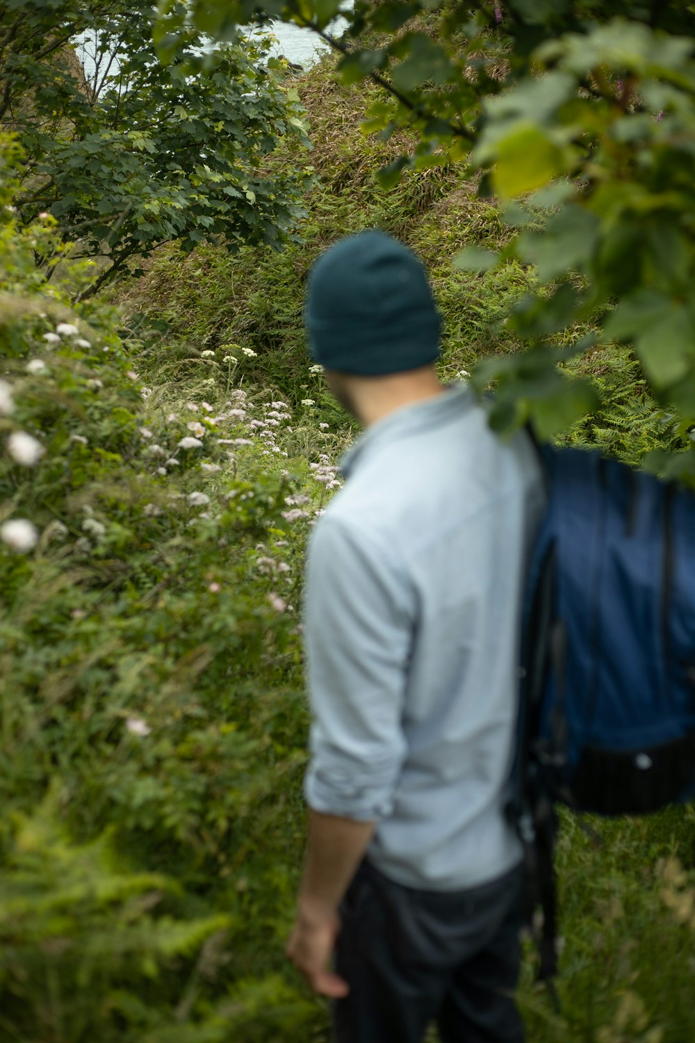 homem na camisa social branca que está ao lado das plantas verdes durante o dia