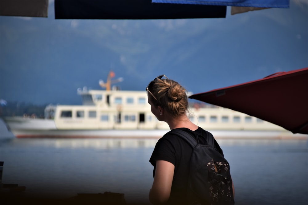 woman in black crew neck t-shirt standing near body of water during daytime