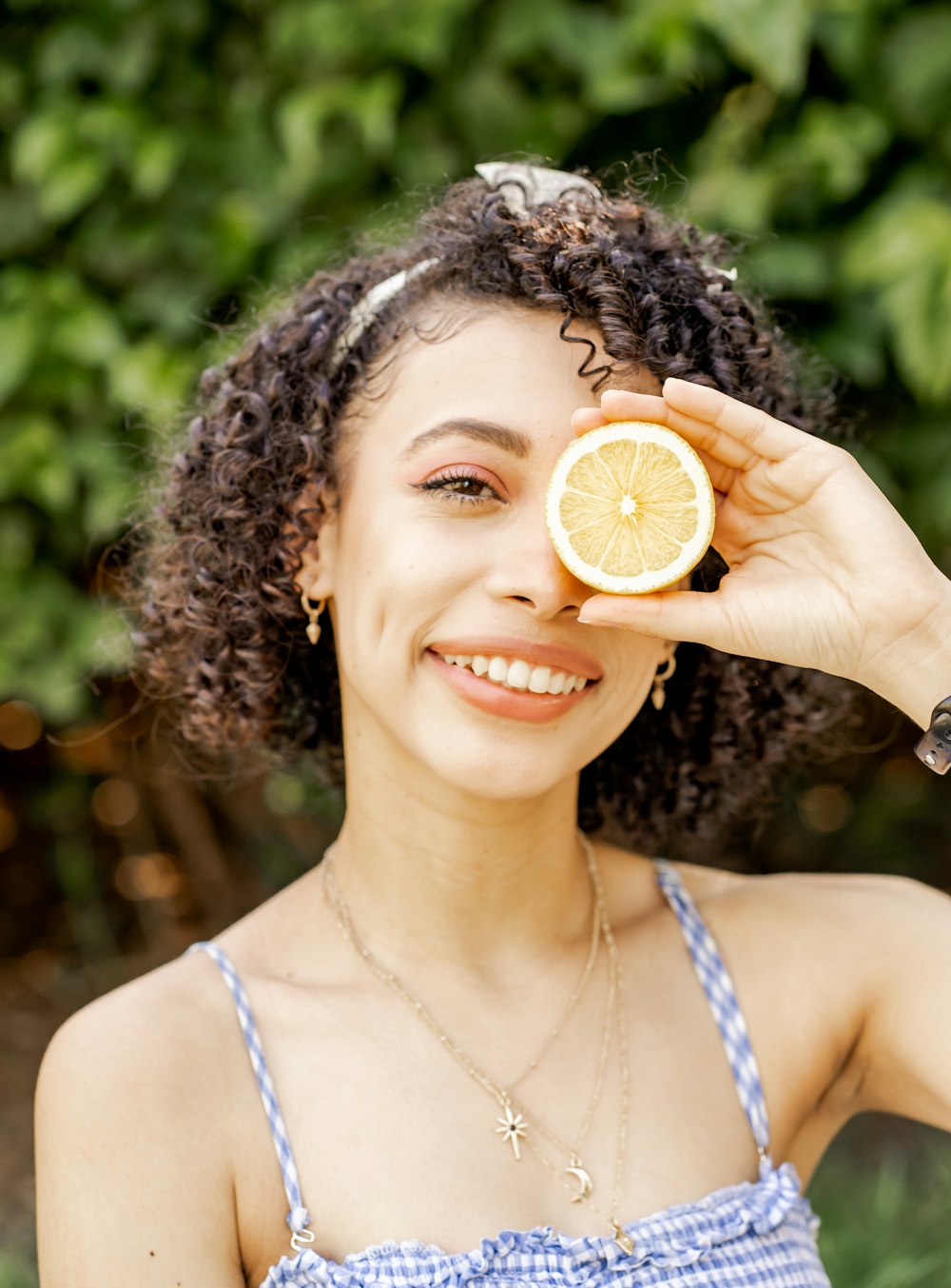 smiling woman in white tank top holding silver round coin