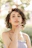 woman in white tank top with gold necklace