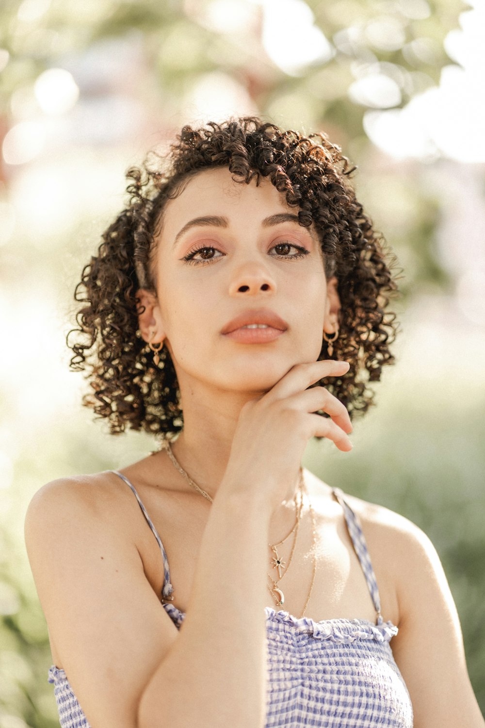 woman in white tank top with gold necklace