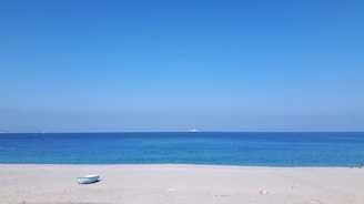 white boat on white sand beach during daytime