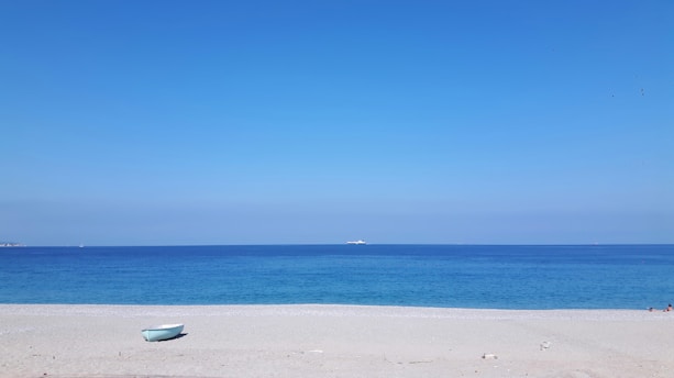 white boat on white sand beach during daytime