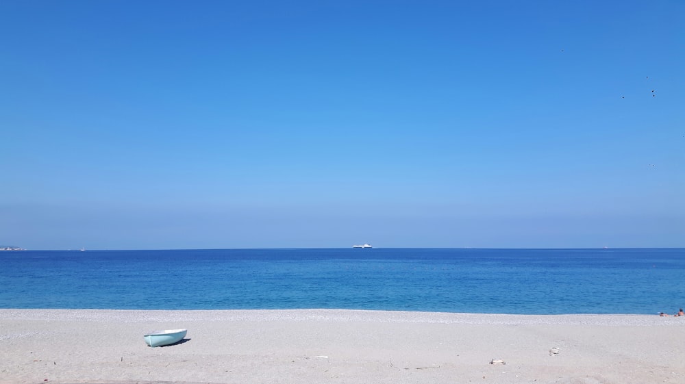 Barco blanco en la playa de arena blanca durante el día