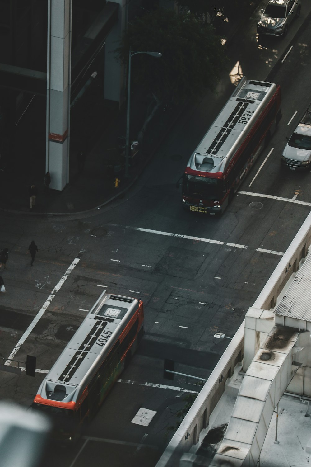 昼間の道路を走る赤いバス