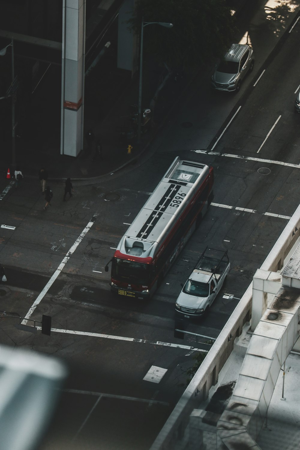昼間の道路を走る赤いバス