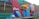 A colorful mural painted on the side of a building, featuring geometric shapes and patterns. The words 'Create More' are prominently displayed in white against a vibrant background of red, blue, teal, and orange. The artwork includes stylized clouds integrated into the design.
