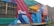 A colorful mural painted on the side of a building, featuring geometric shapes and patterns. The words 'Create More' are prominently displayed in white against a vibrant background of red, blue, teal, and orange. The artwork includes stylized clouds integrated into the design.