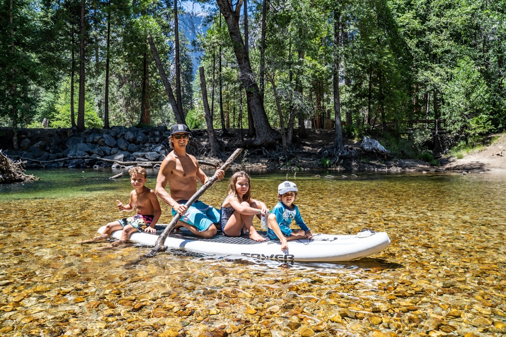 3 women and 2 men riding on boat during daytime