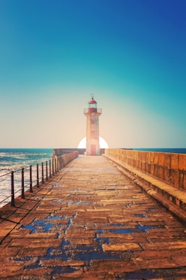white and black lighthouse on dock during daytime