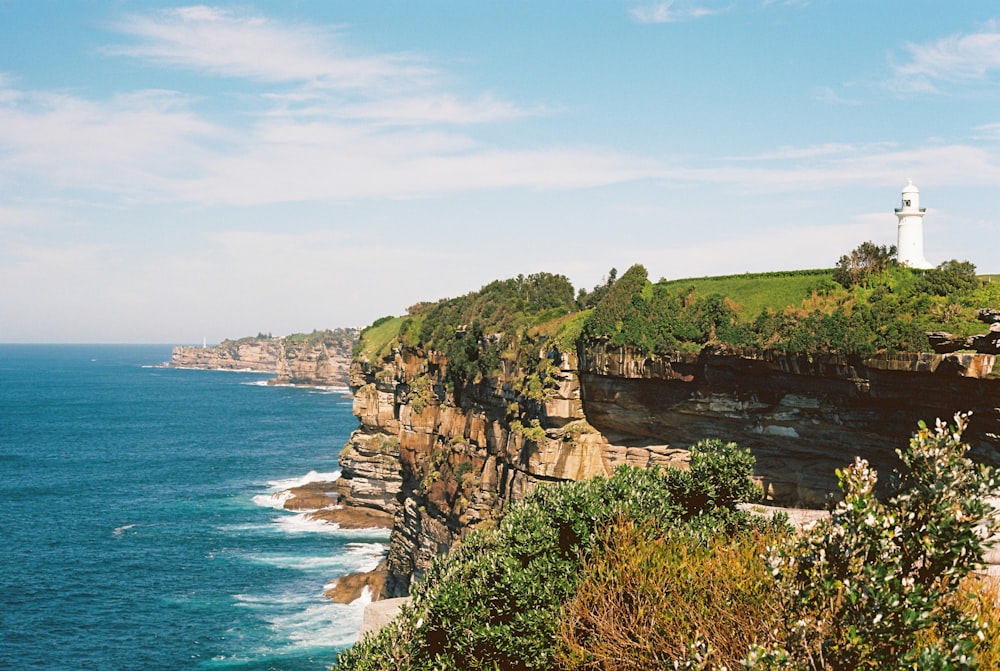 a lighthouse on a cliff overlooking the ocean