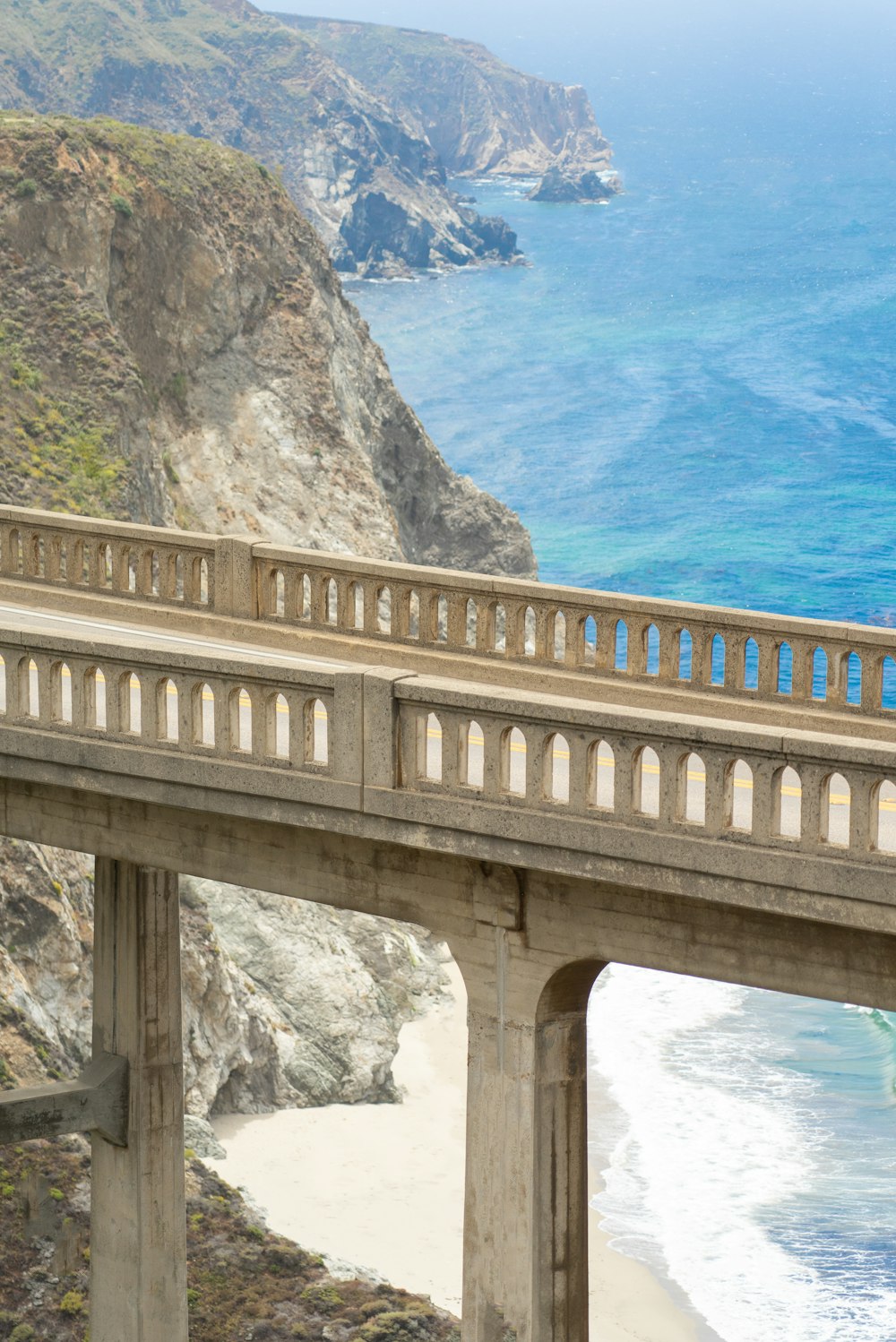 brown concrete bridge over blue body of water during daytime