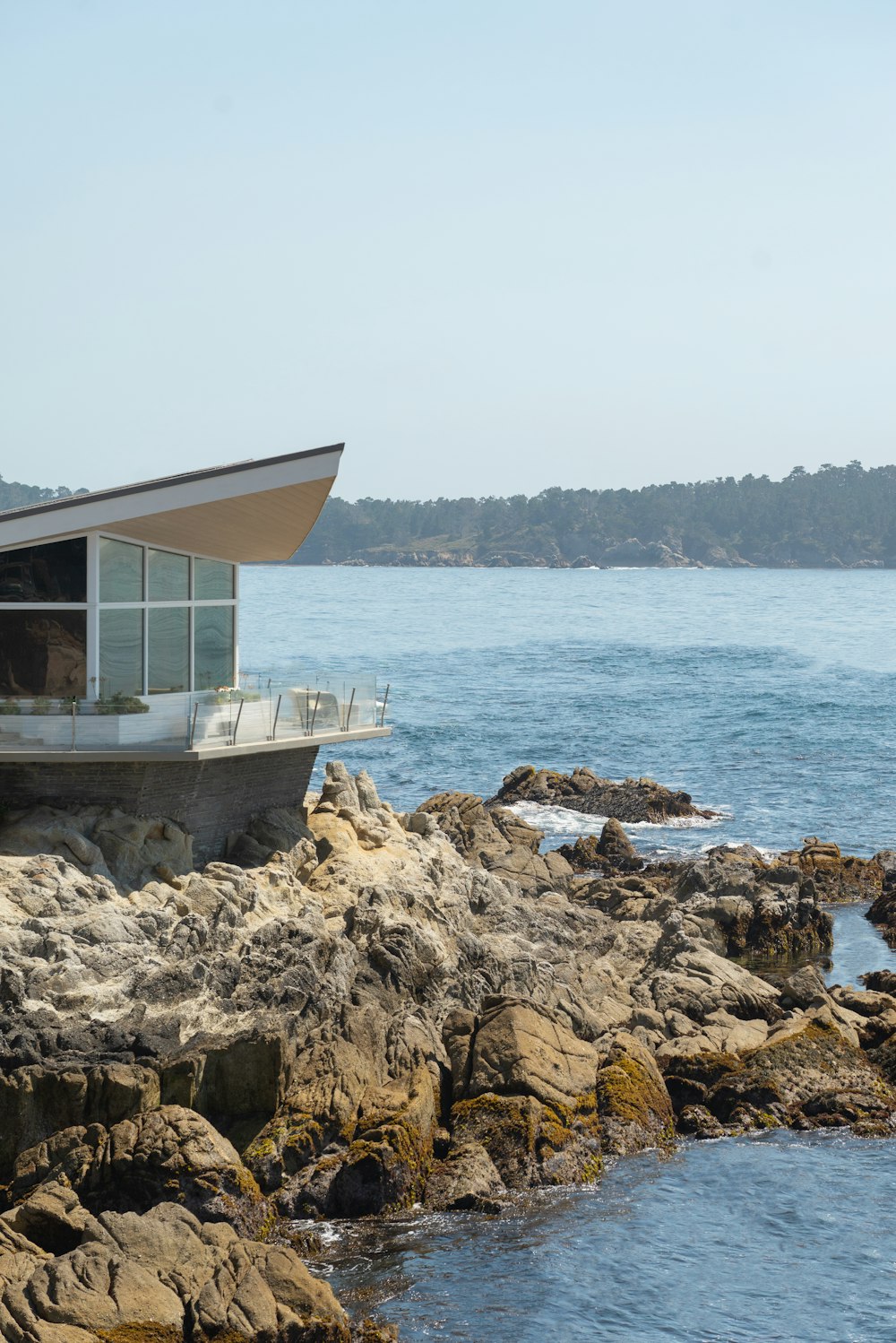 white and brown wooden house on rocky shore during daytime