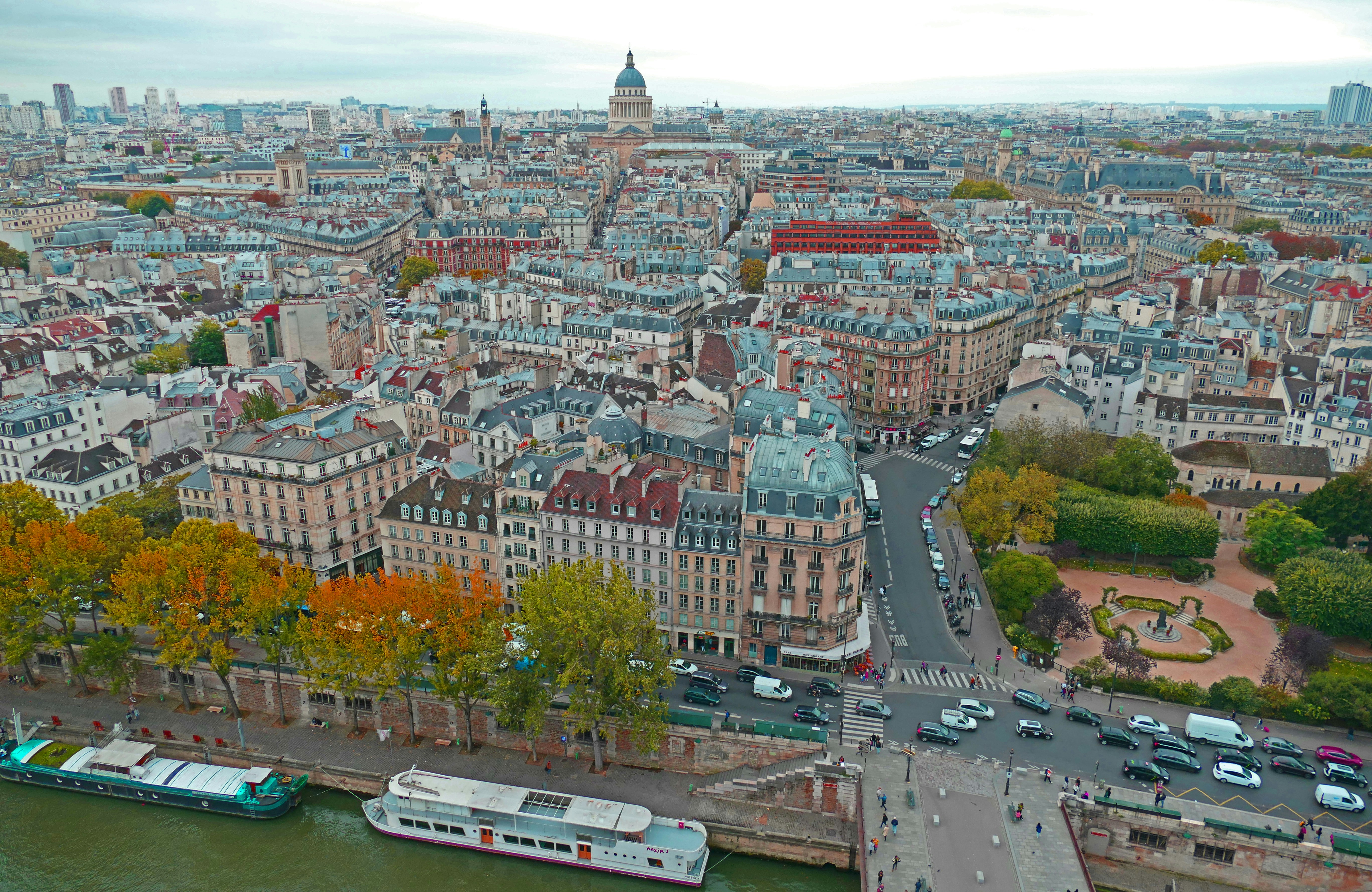 A young lady with a green coat walking. The title 'Emily in Paris' can be seen in the background