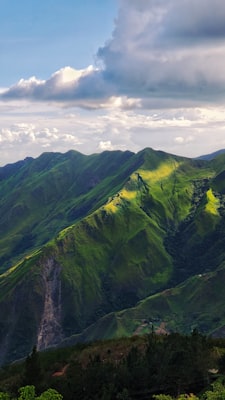Verdant mountain landscape beneath white clouds in Venezuela — photo by Jorge Salvador on Unsplash