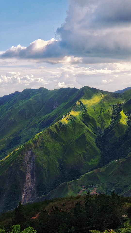 green mountain under white clouds during daytime in Colonia Tovar Venezuela