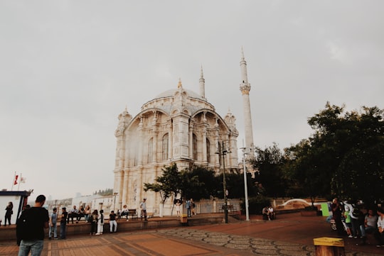 people walking on sidewalk near white concrete building during daytime in Ortaköy Mosque Turkey