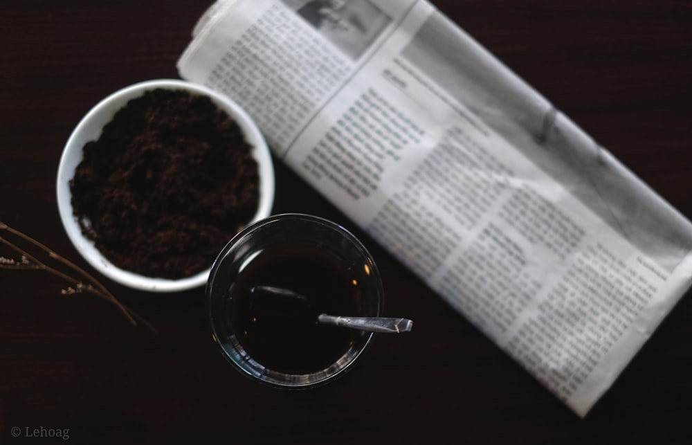 black liquid in clear glass mug on white paper