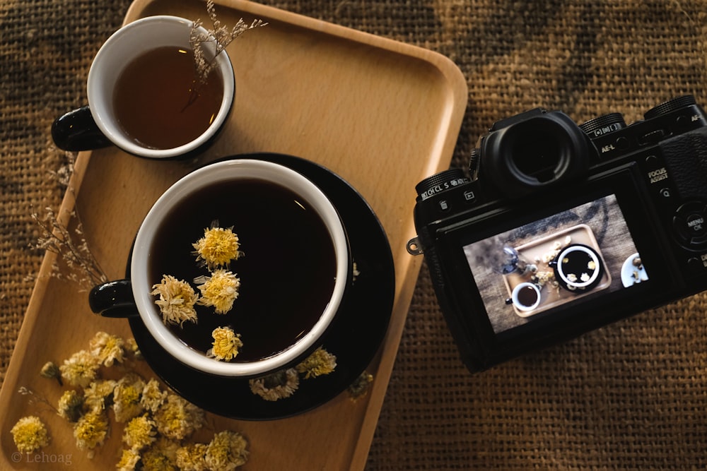black and silver camera beside white ceramic bowl with white and brown liquid