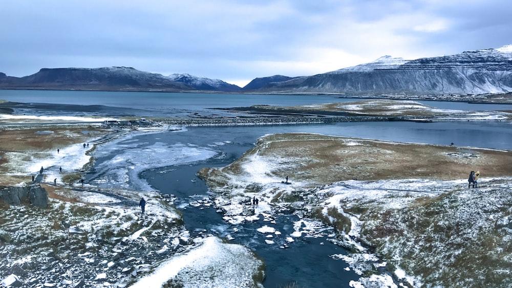 snow covered mountain near body of water during daytime