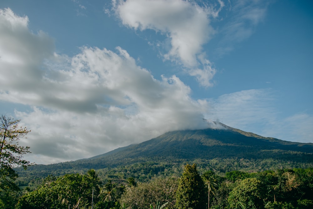 green mountain under white clouds and blue sky during daytime