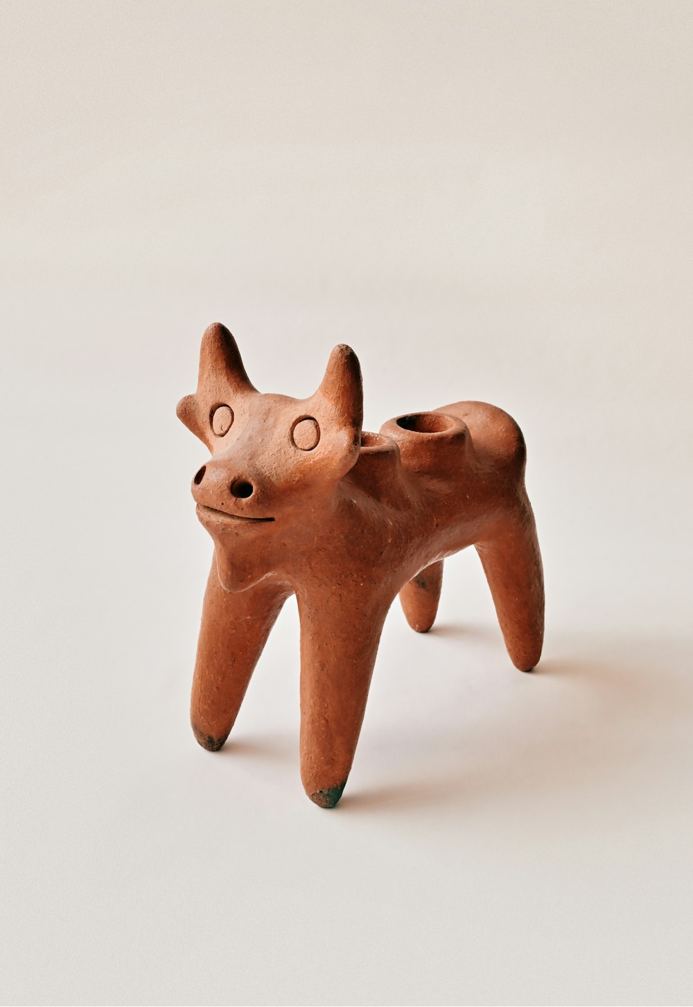 Figurine d’animal en bois marron sur surface blanche