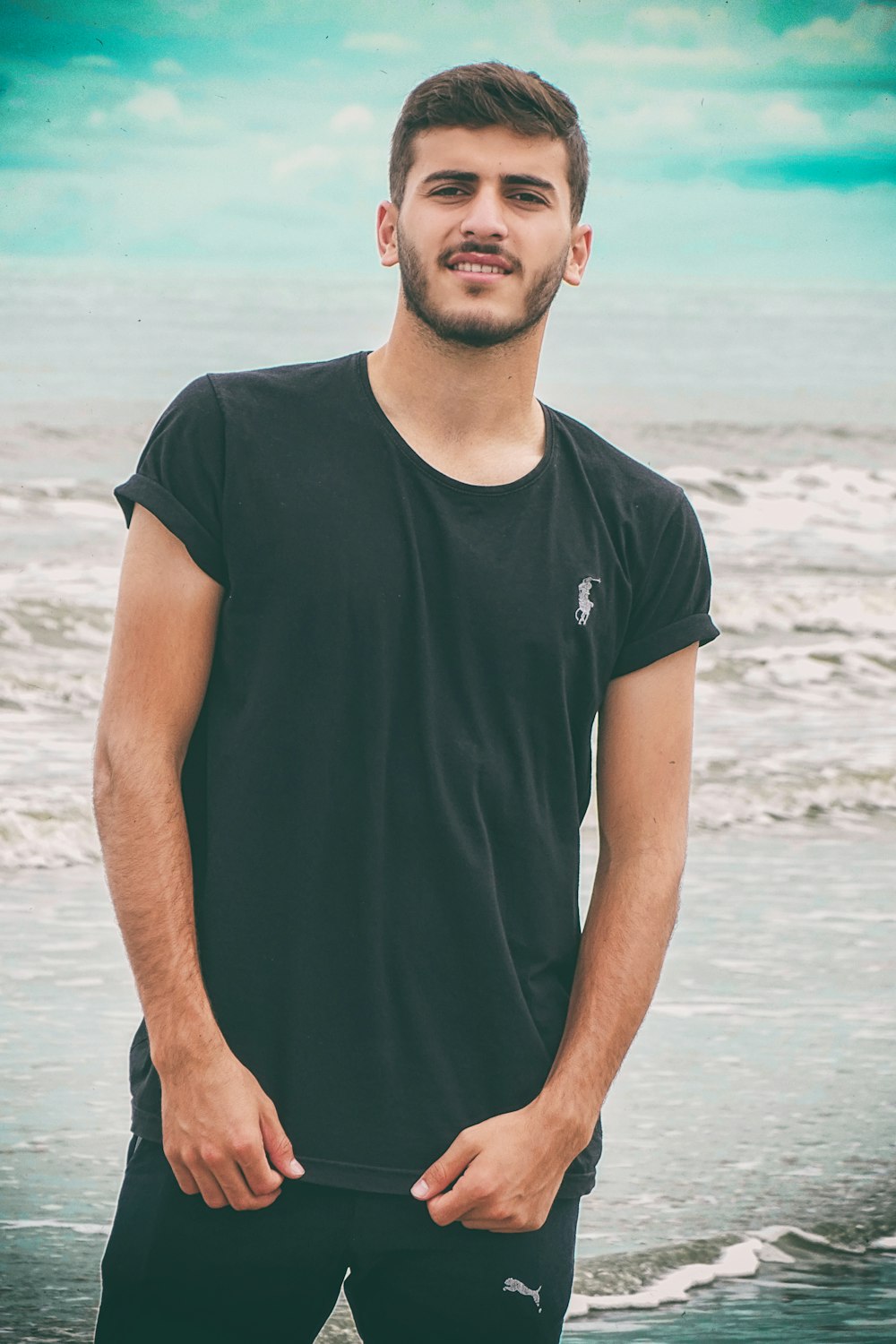man in black crew neck t-shirt standing on beach during daytime