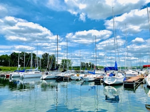 white and blue boats on sea under blue sky during daytime