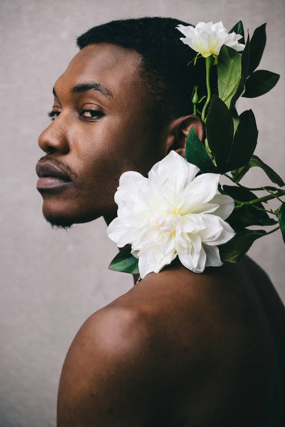 uomo con fiore bianco sull'orecchio