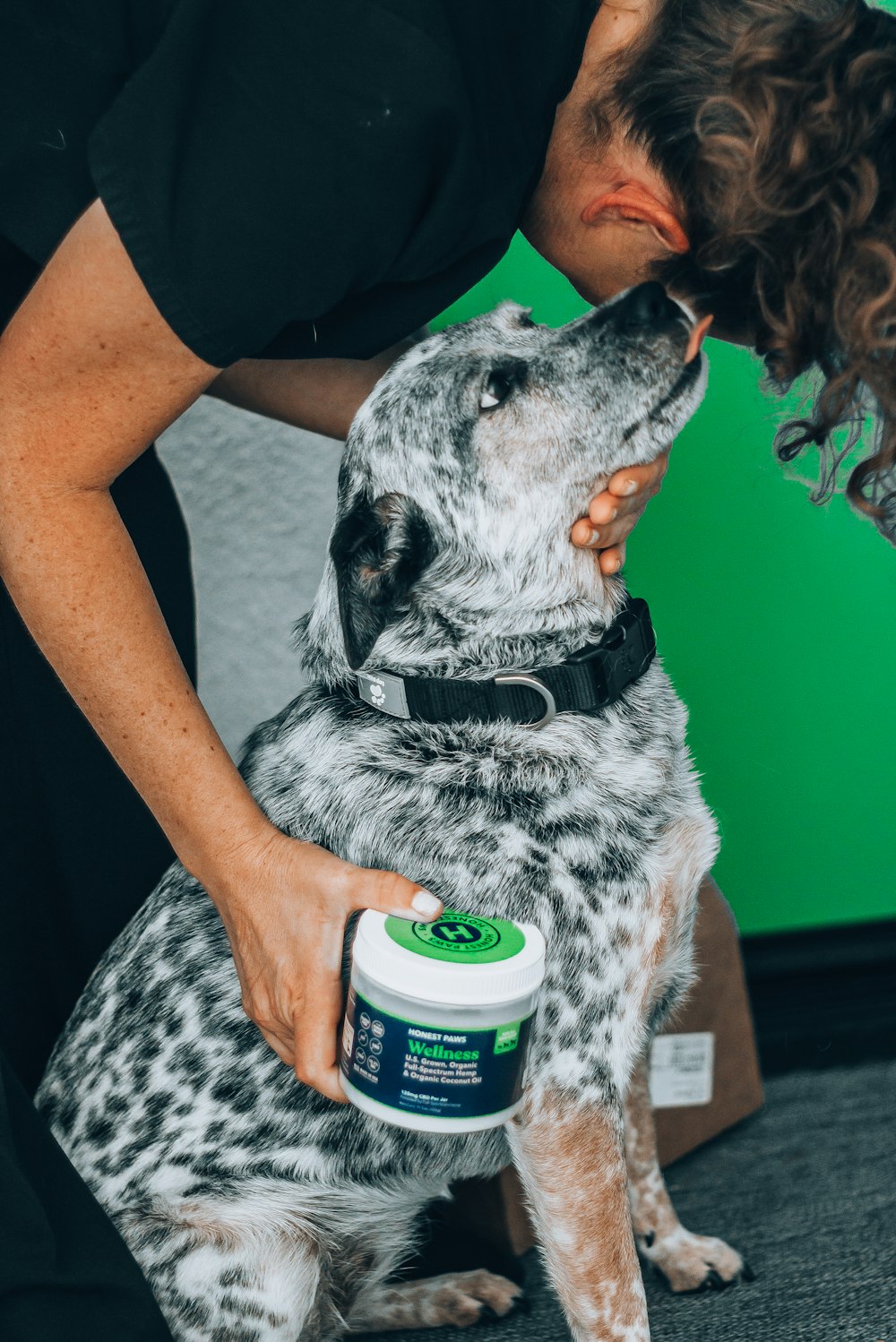 person holding white and green labeled can