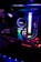 A close-up view of a custom-built computer's internal components, featuring a prominent liquid cooling system from NZXT. Colorful RGB lighting illuminates the interior, giving it a futuristic look. The setup includes a graphics card and various LED-lit cables, all enclosed within a transparent case.