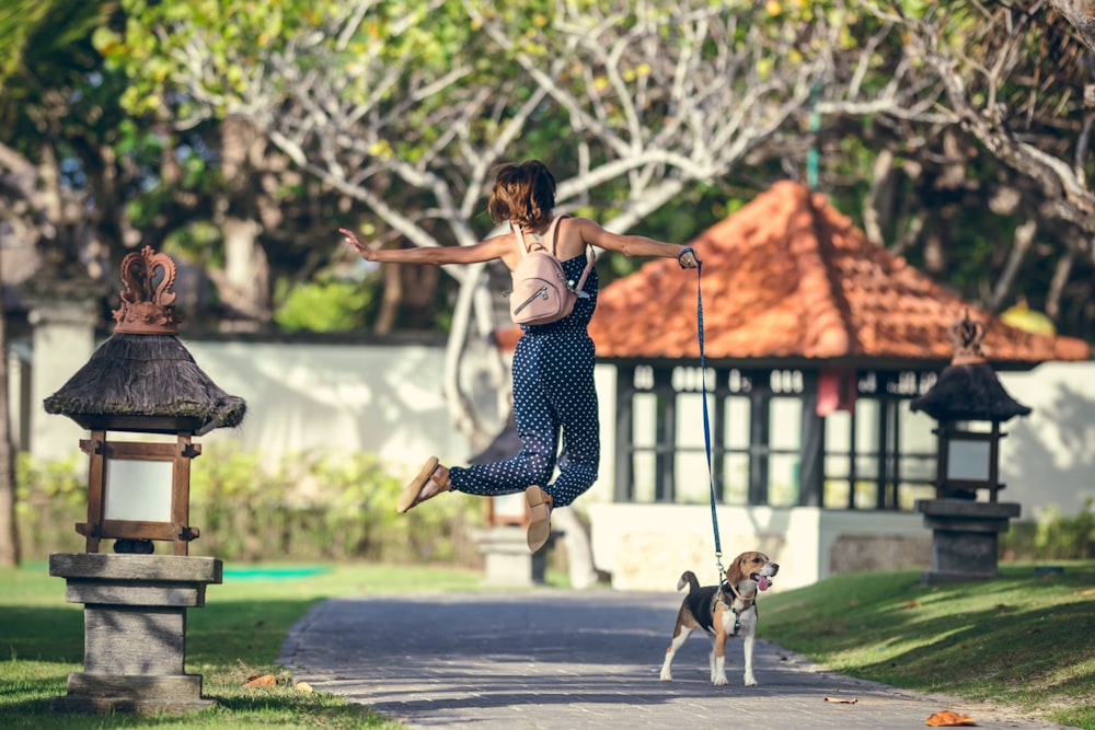 woman in black and white polka dot tank top and black and white pants jumping on near near near near