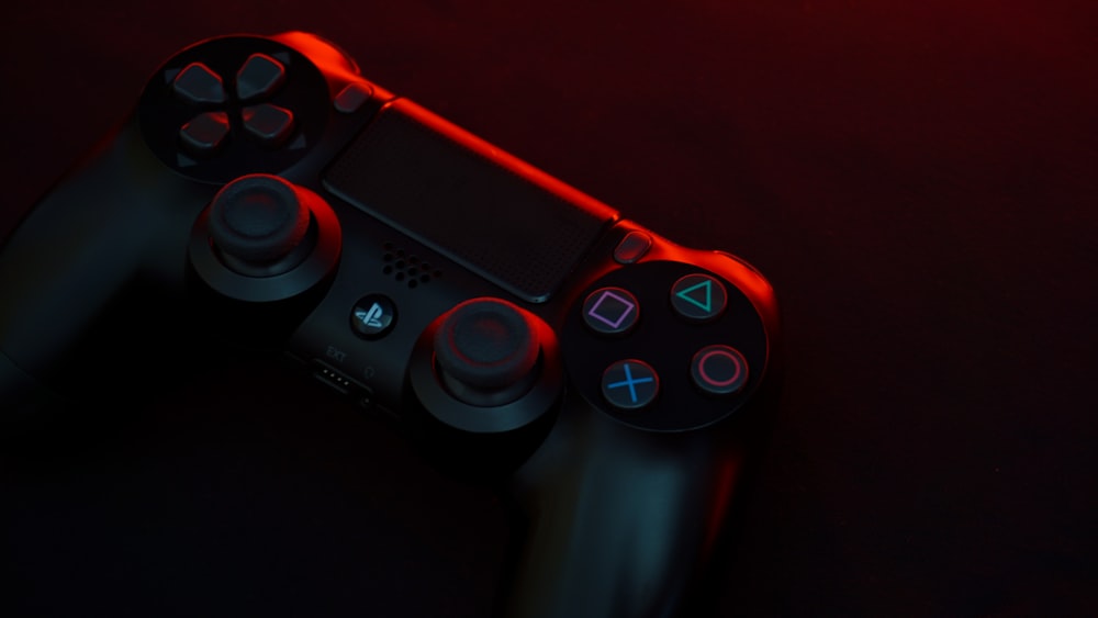 red and black sony ps 4 game controller