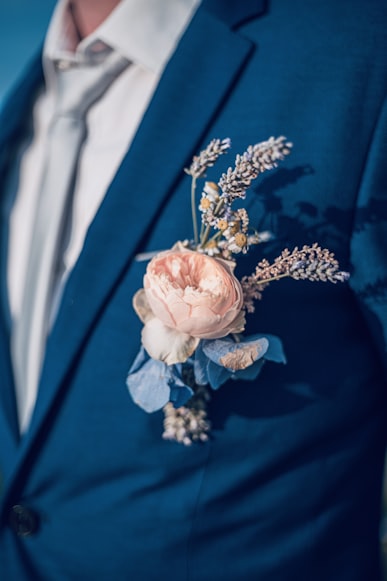 Boutonnière avec des fleurs séchées (pivoine, lavande, marguerite, hortensia bleu) sur un costume bleu