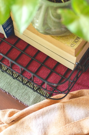 Storage rattan end table styled with books and a small plant.