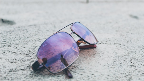 PolarX One sunglasses in deep blue shade with polarized lenses resting on a mountain bike handlebar