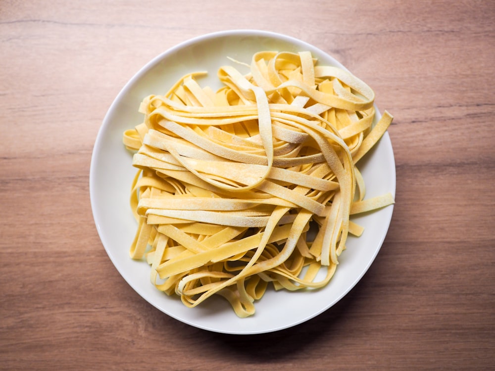 yellow pasta on white ceramic plate