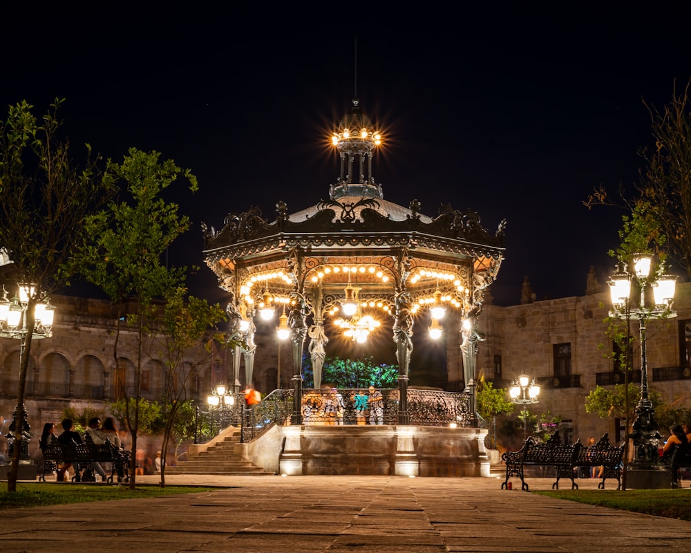 a gazebo lit up at night in a park