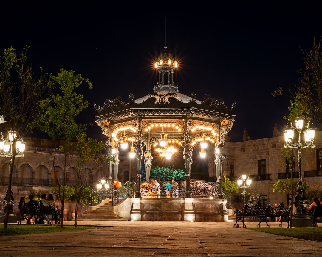a gazebo lit up at night in a park,