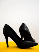 black leather heeled shoes on yellow chair